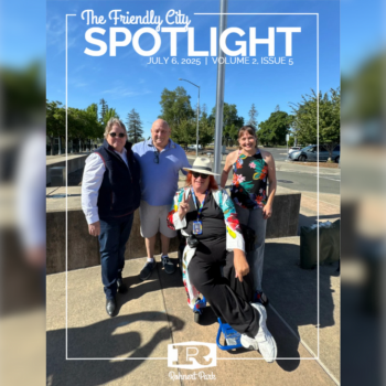 Four people pose in front of a flag pole after raising the Pride flag
